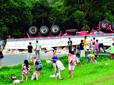 Caminhão tomba e população saqueia carga de arroz