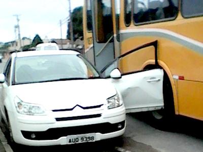 Abre a porta do veículo e bate em ônibus